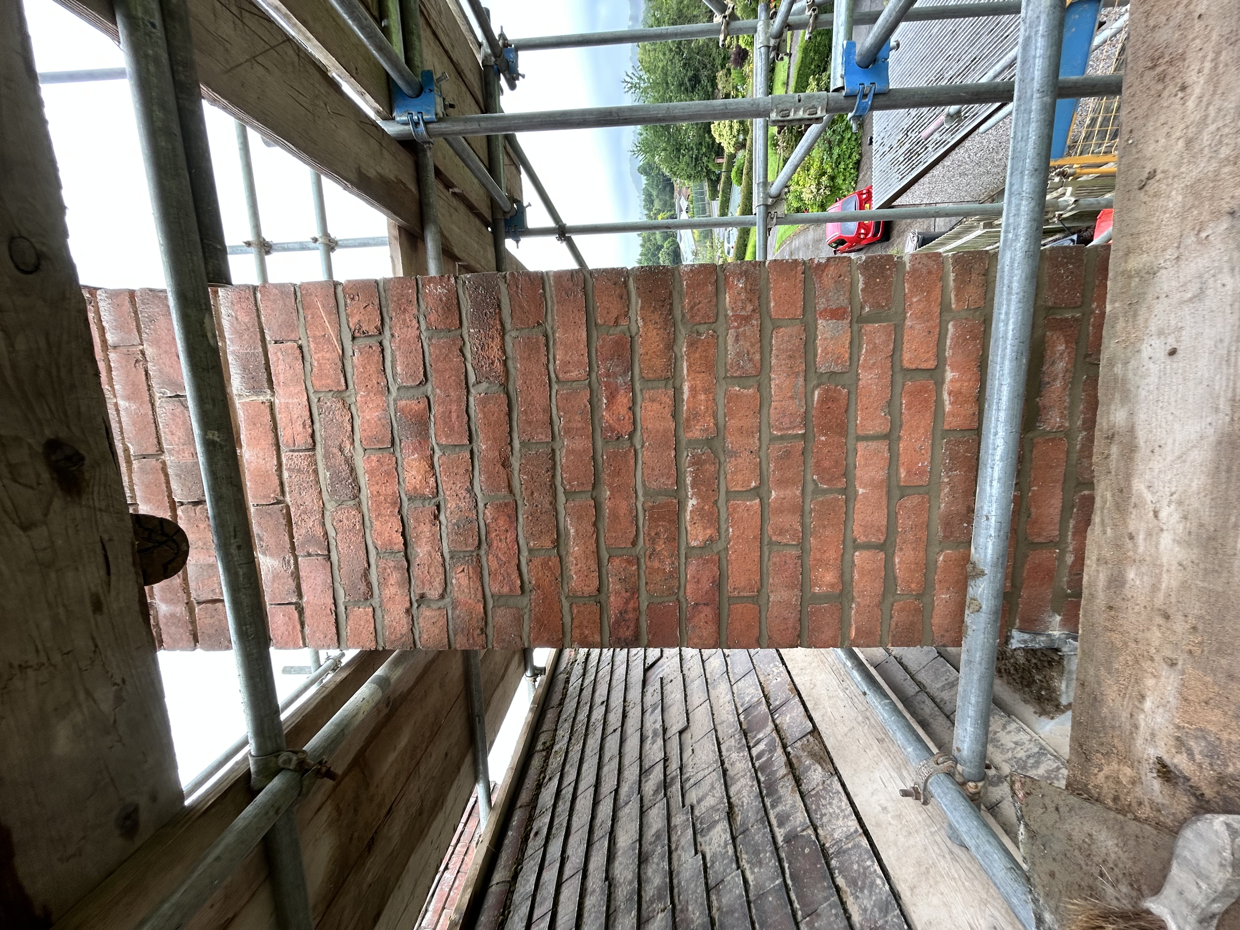 Roof photographed from above showing neatly laid courses of tiles and a clean ridge line