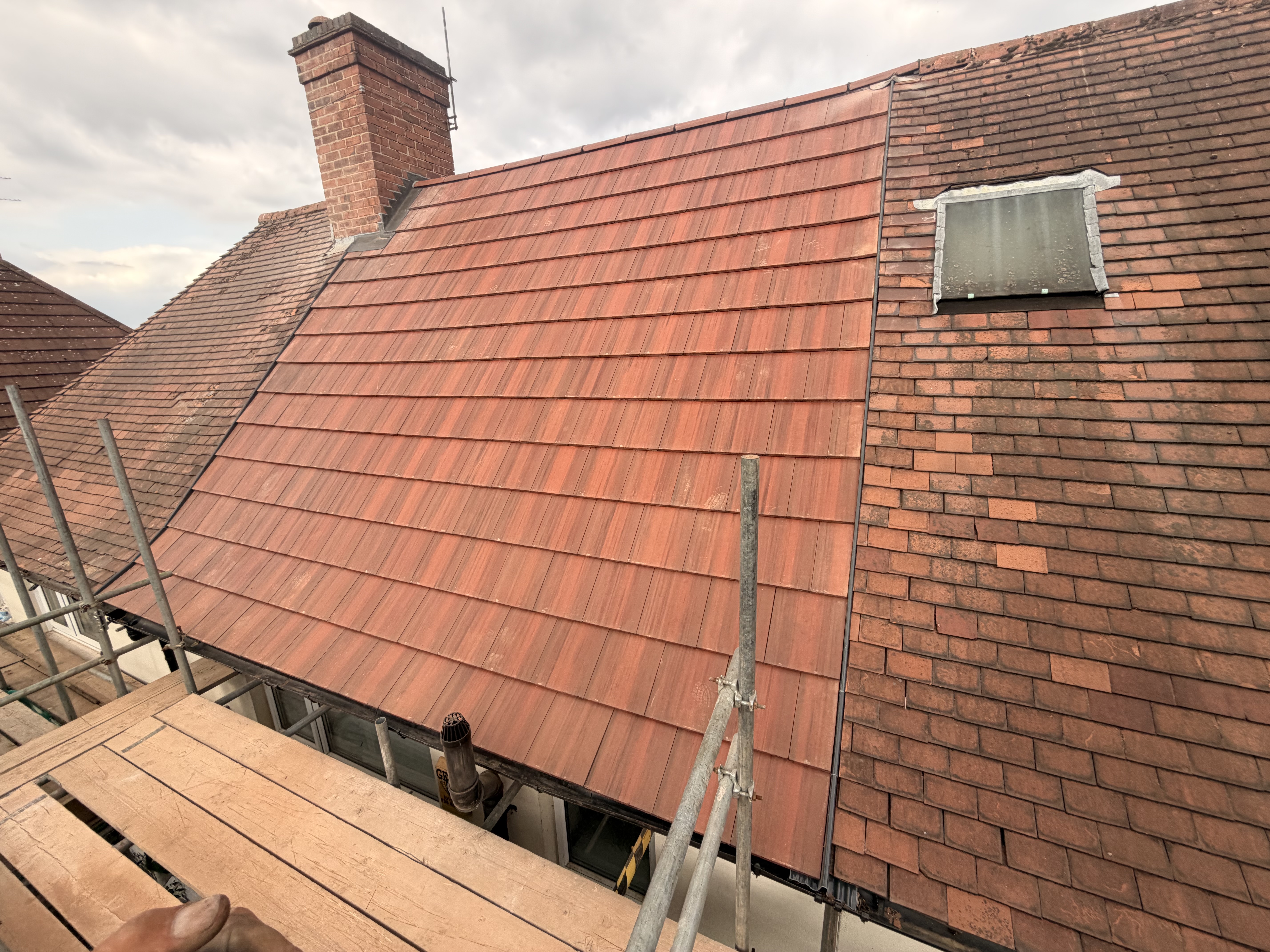 Completed roof and guttering on a house, photographed from above on a grey day