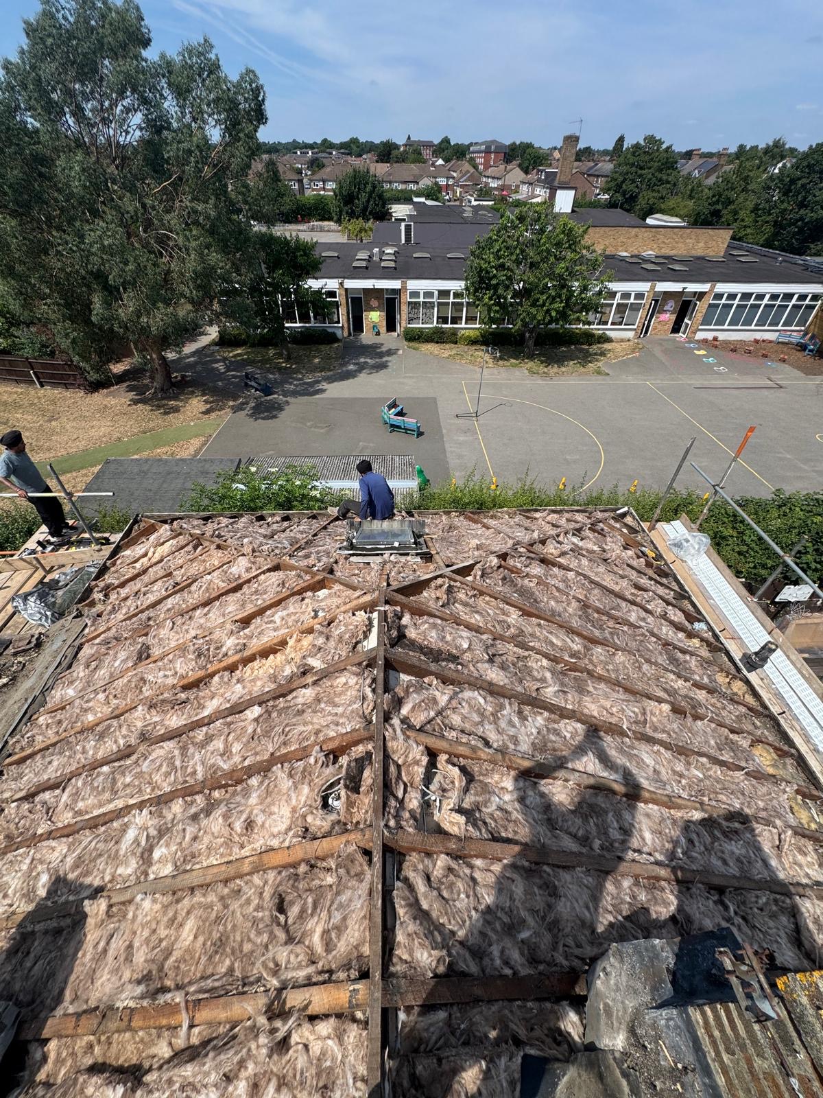 Close view of ridge tiles bedded along the top of a grey tiled roof