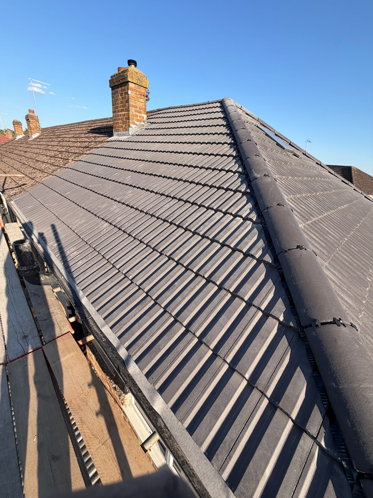 Hip roof with new tiles and lead flashing worked around the chimney