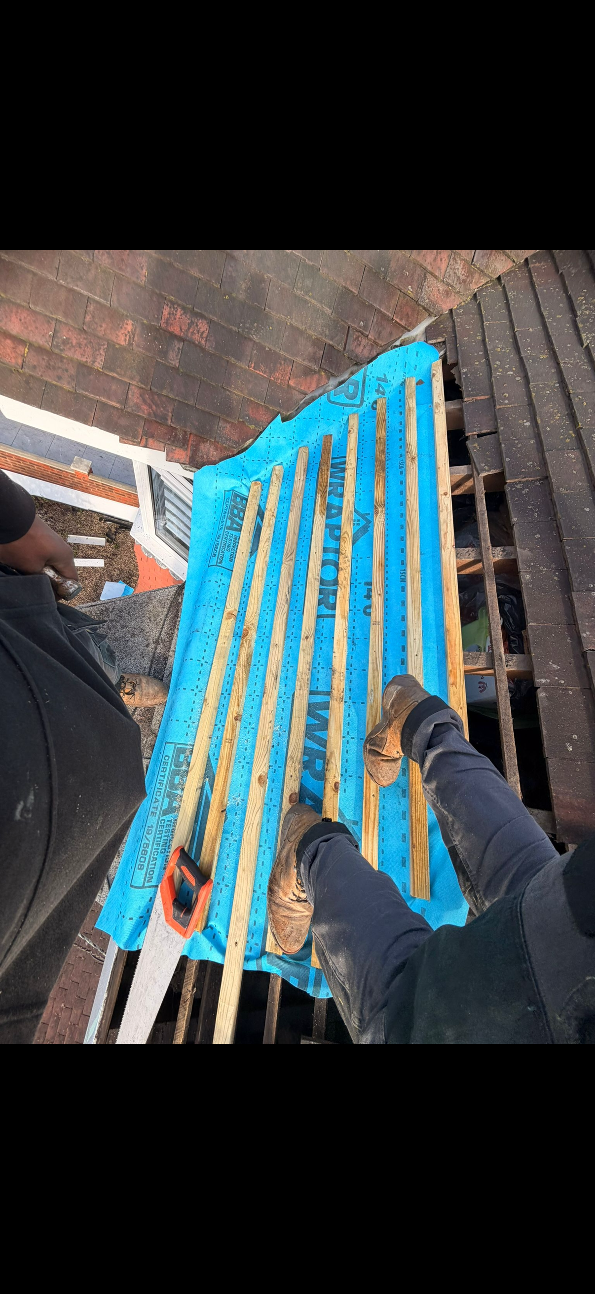 Lead flashing dressed neatly where a roof slope meets a brick wall