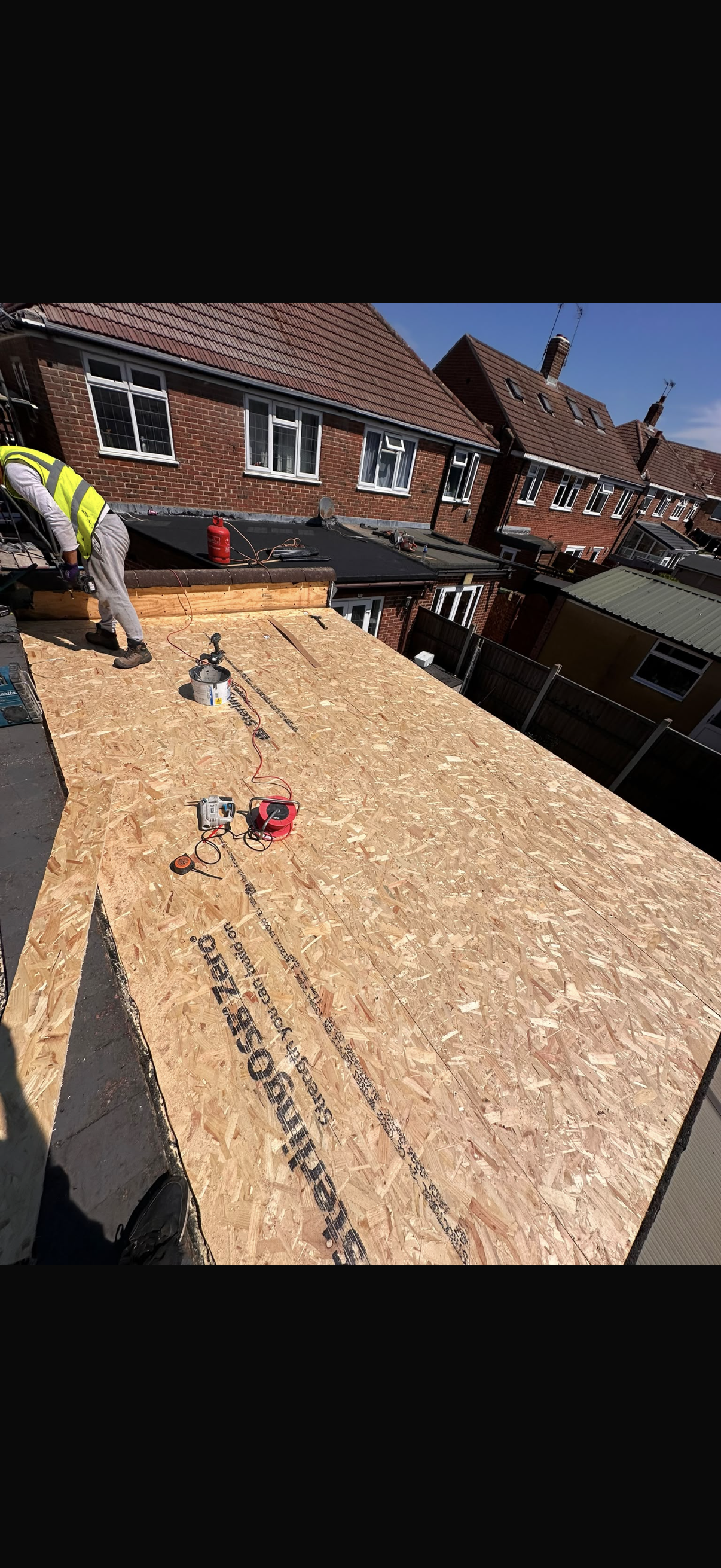 Roof and chimney finished, photographed from the scaffold in bright sun
