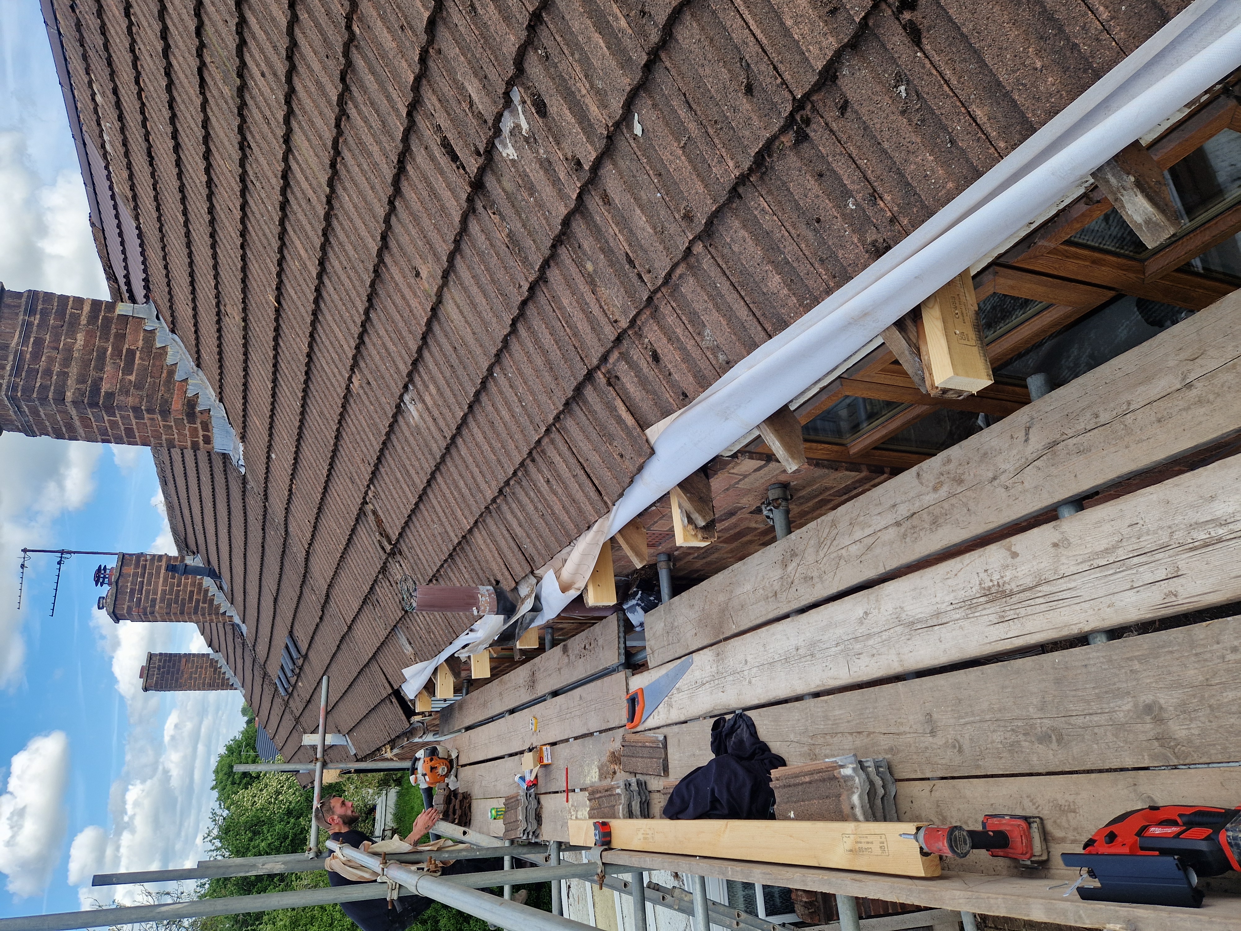 Roofers working on a scaffolded pitched roof