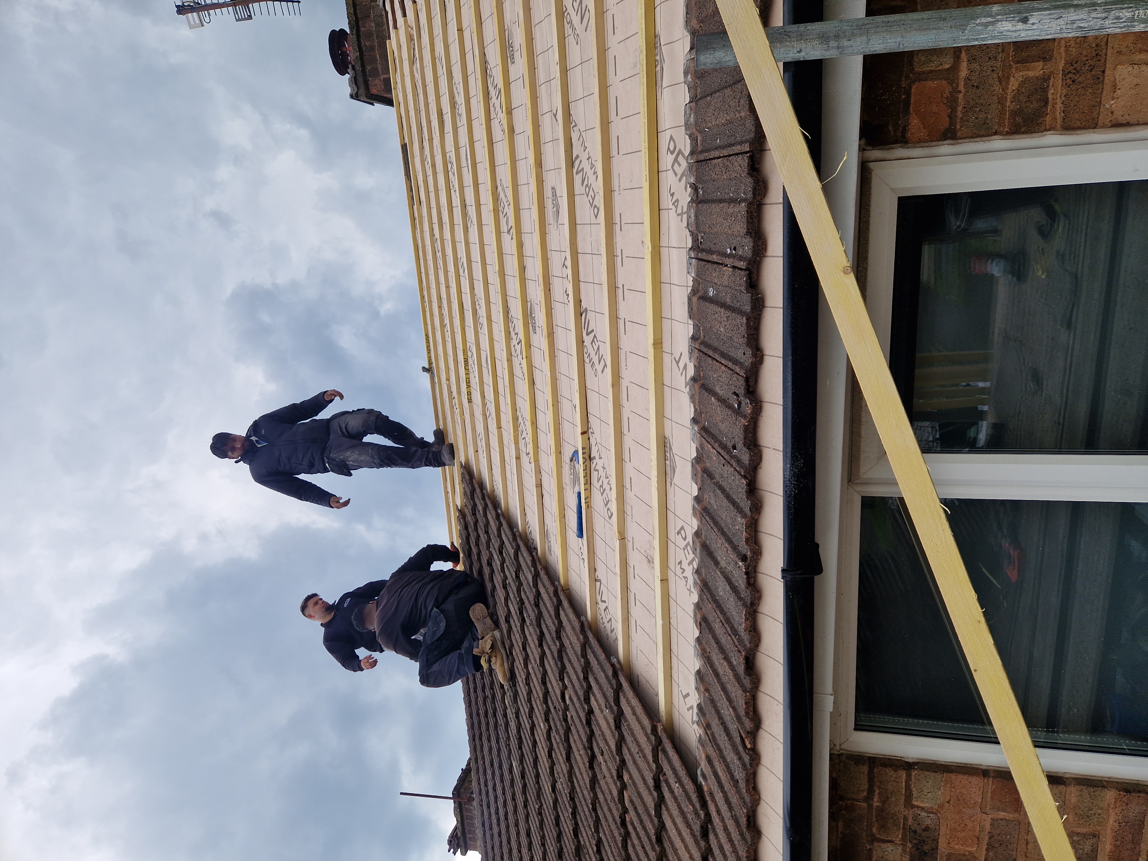 New ridge tiles bedded along the top of a roof