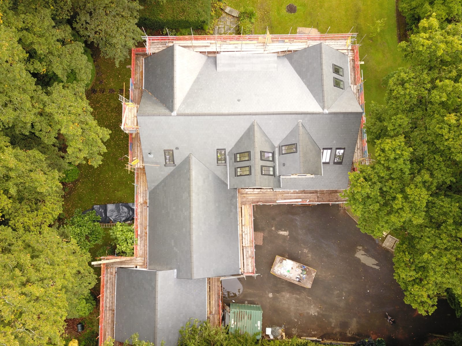 Grey slate roof on a house with new dark ridge tiles along the apex