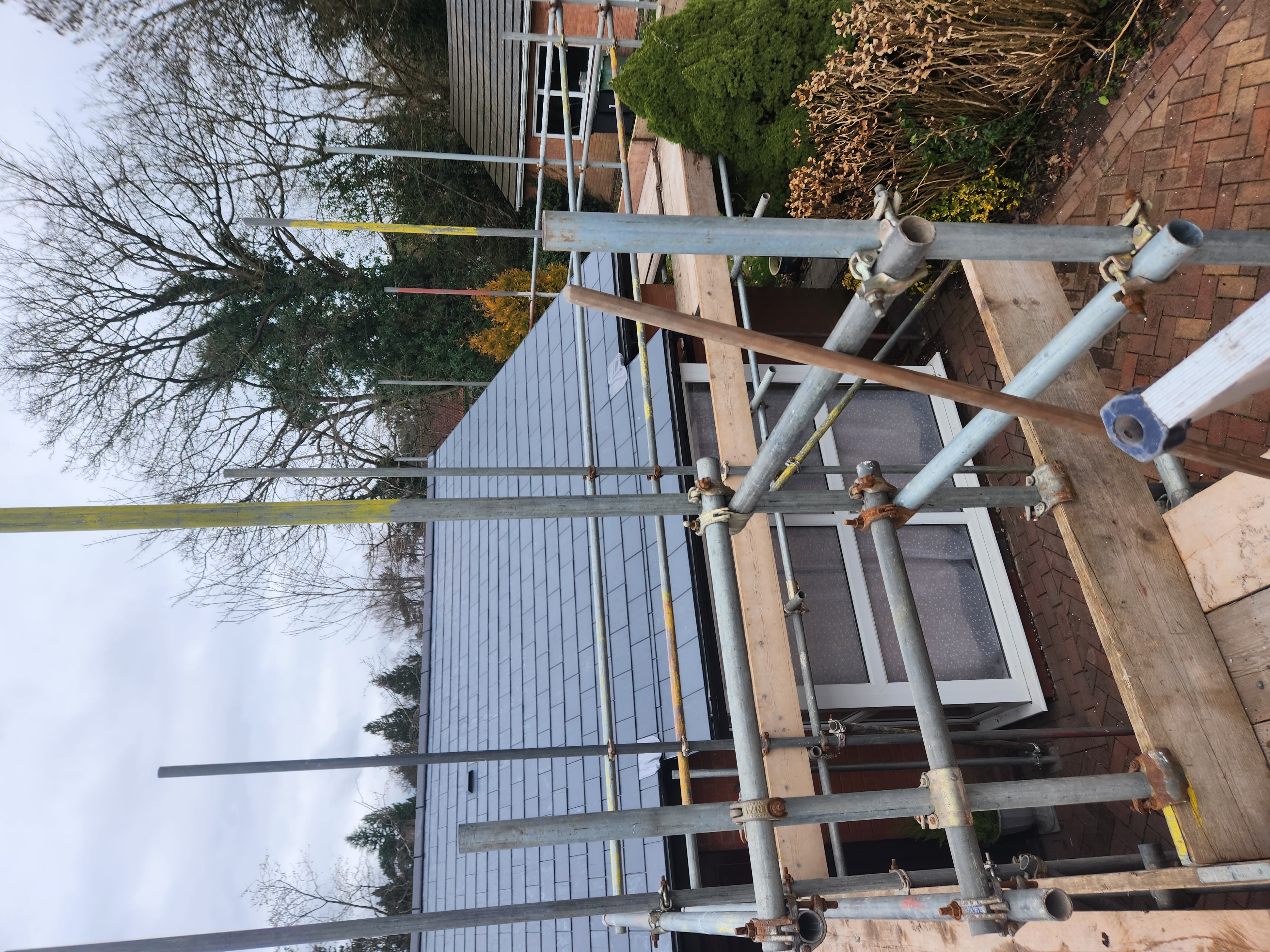 New grey slates laid in neat courses across a large roof slope