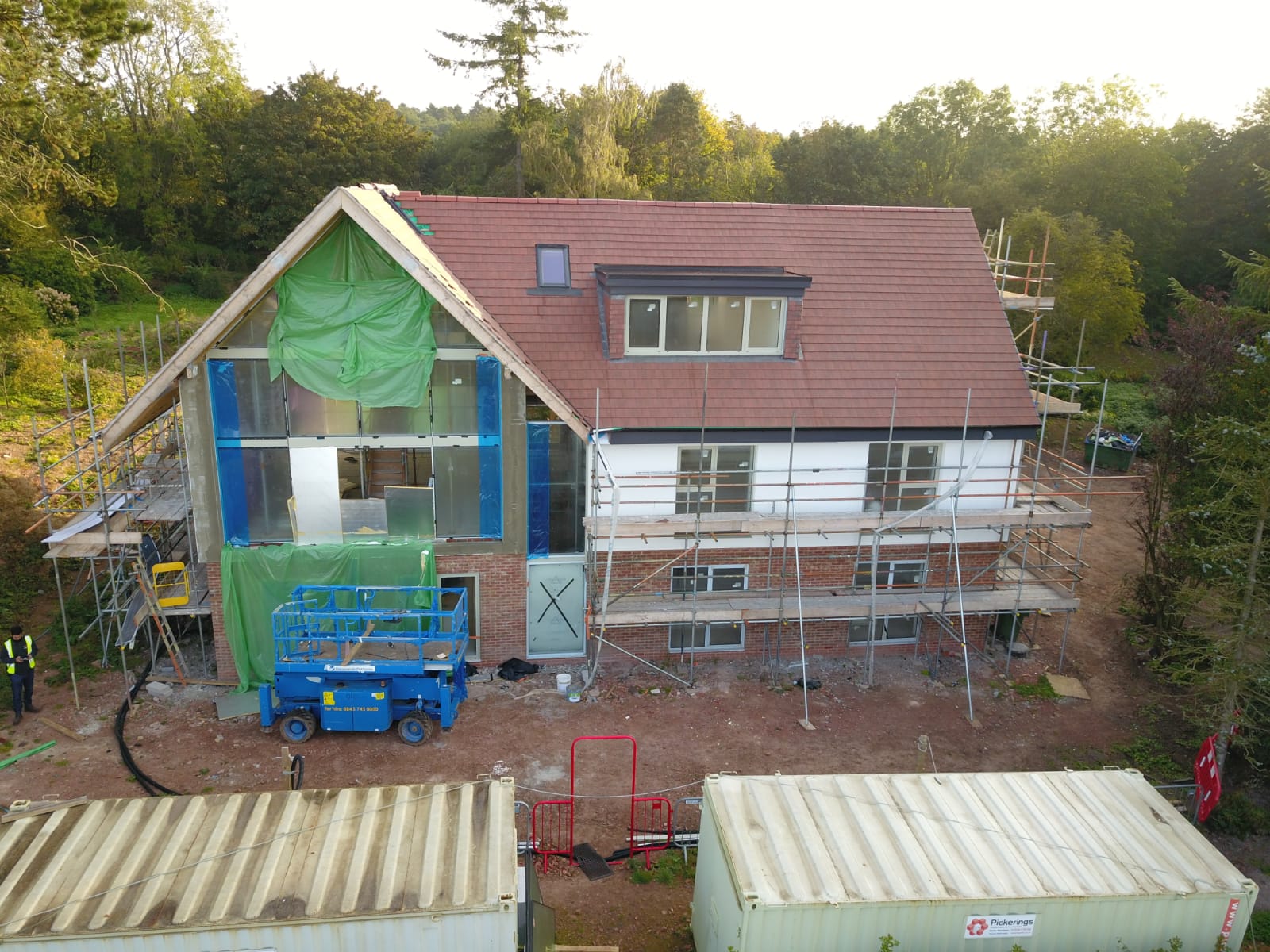 Pitched roof re-covered in grey tiles with brick gable end