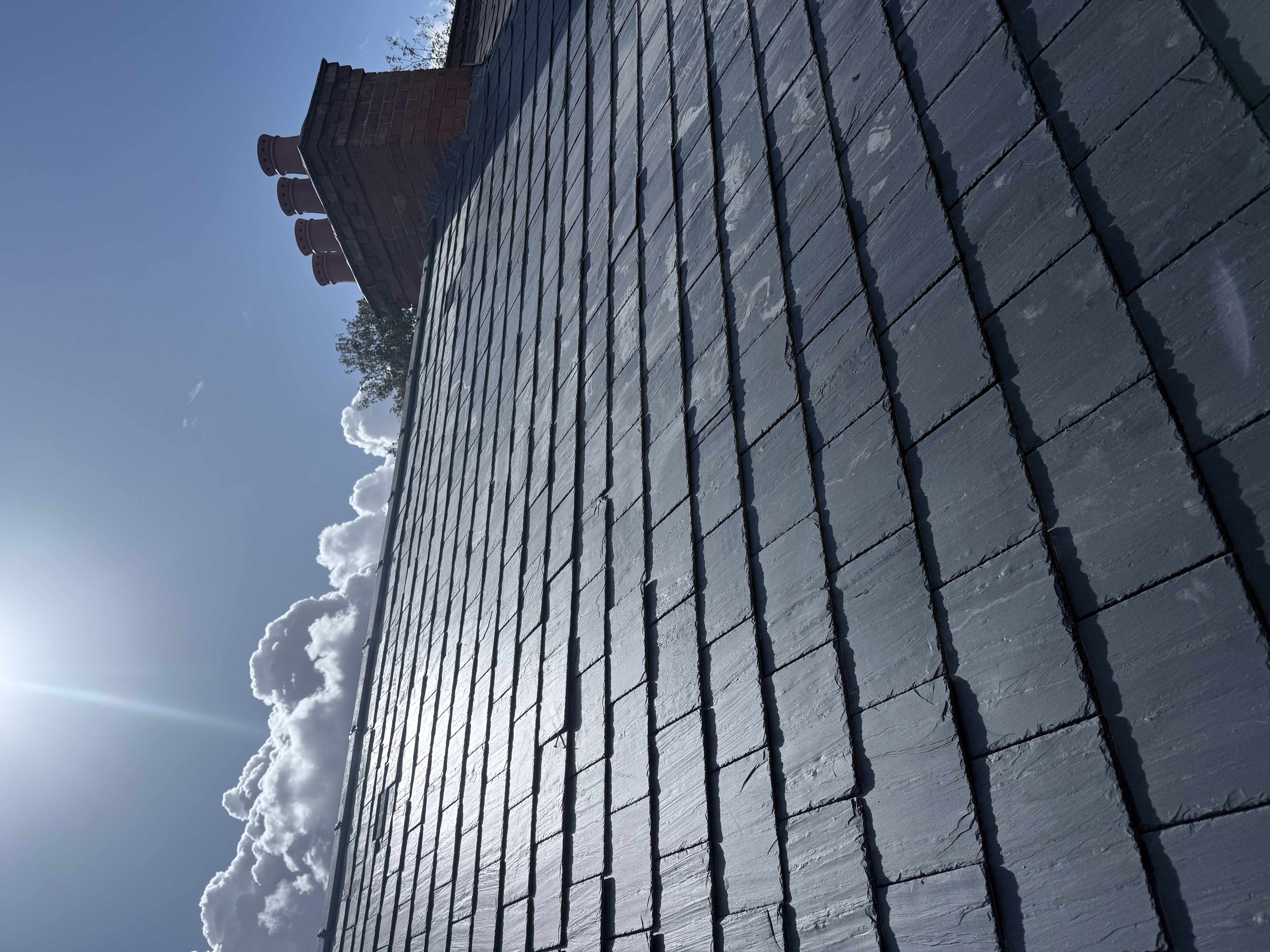 Roof slope in new tiles beside a rendered gable wall