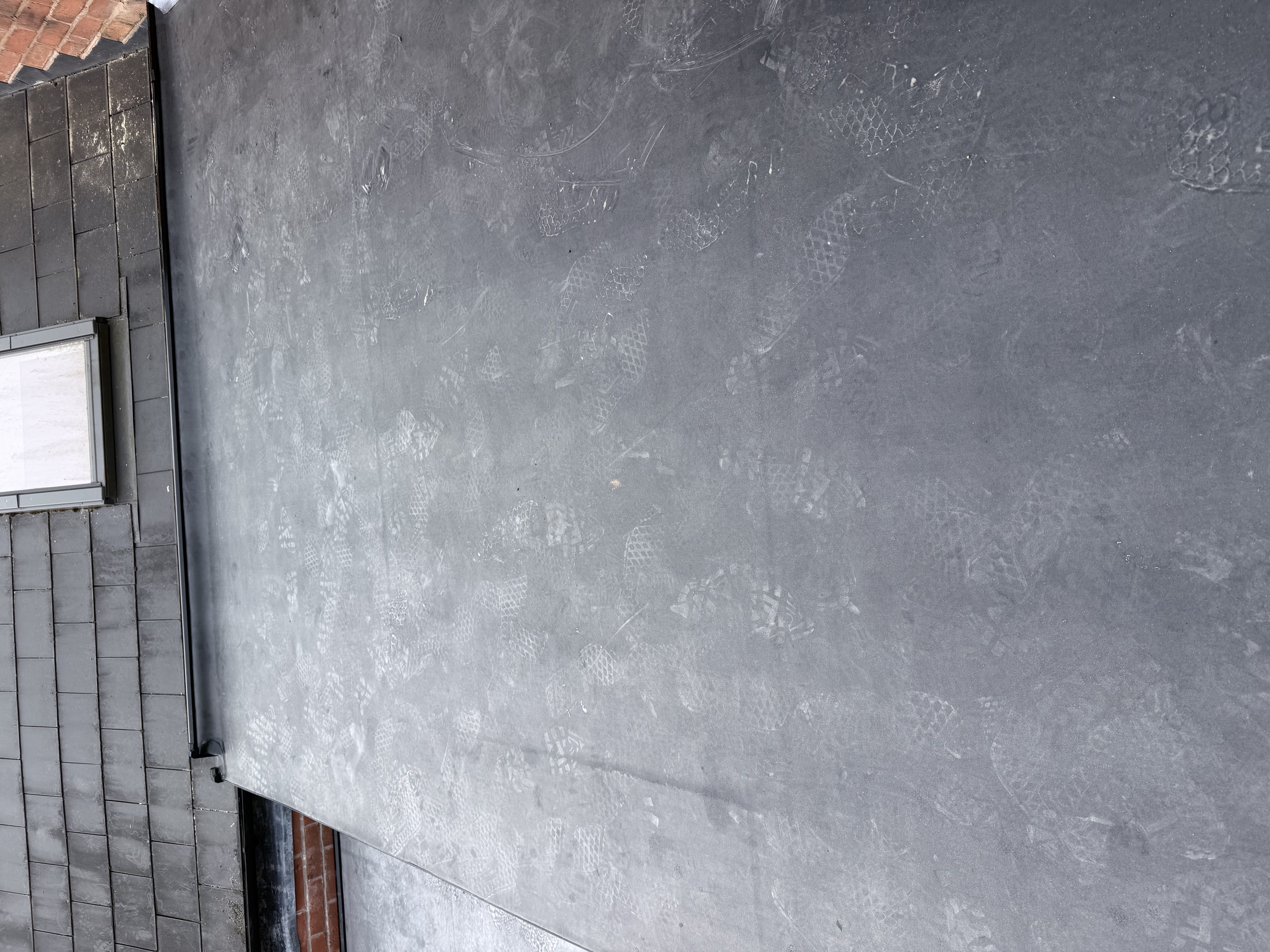 Slated pitched roof with new lead flashing to a brick wall