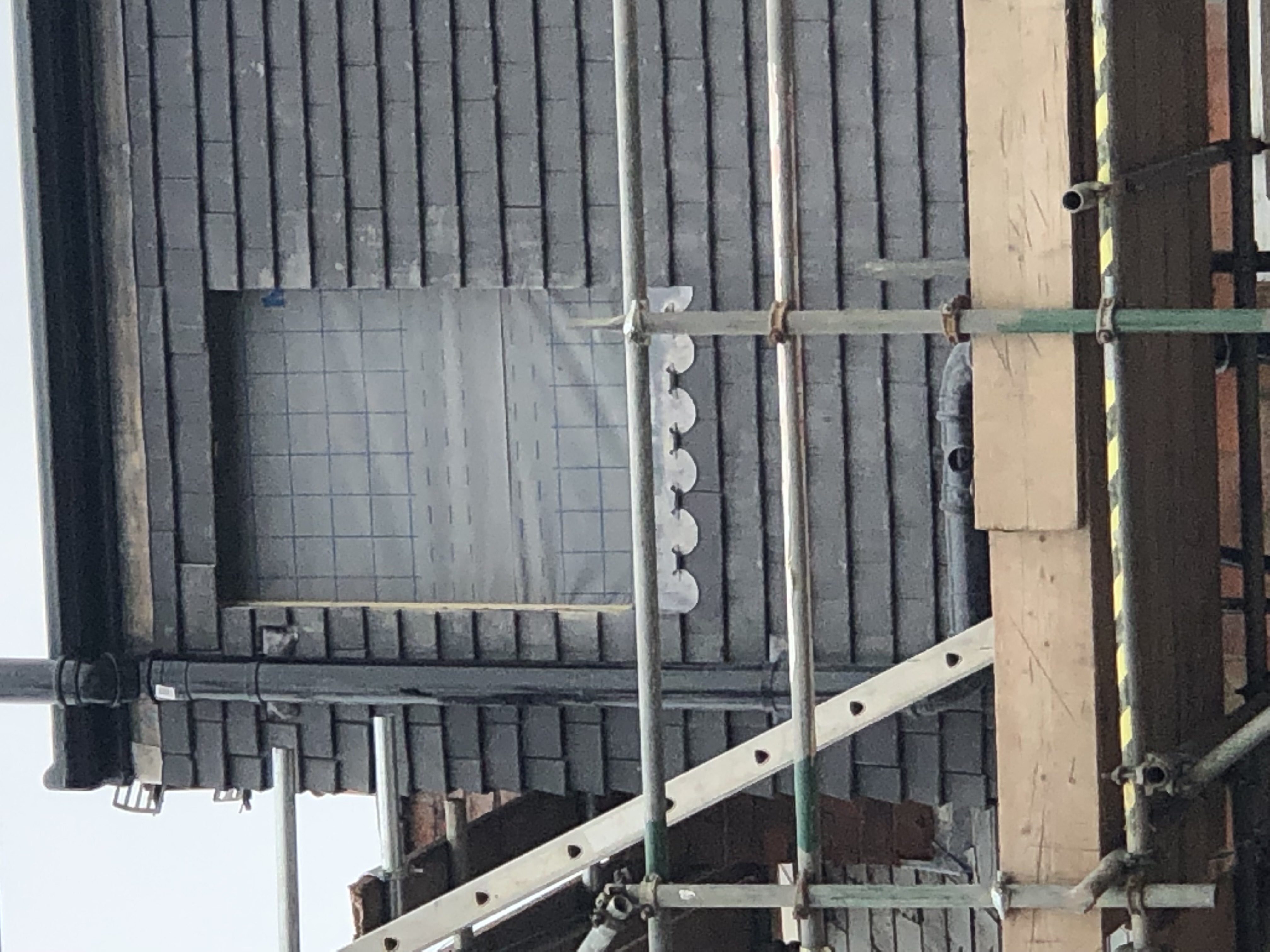 Grey slate roof finished on a large house surrounded by trees