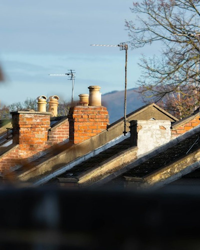 Brick chimney stacks along a row of terraced roofs