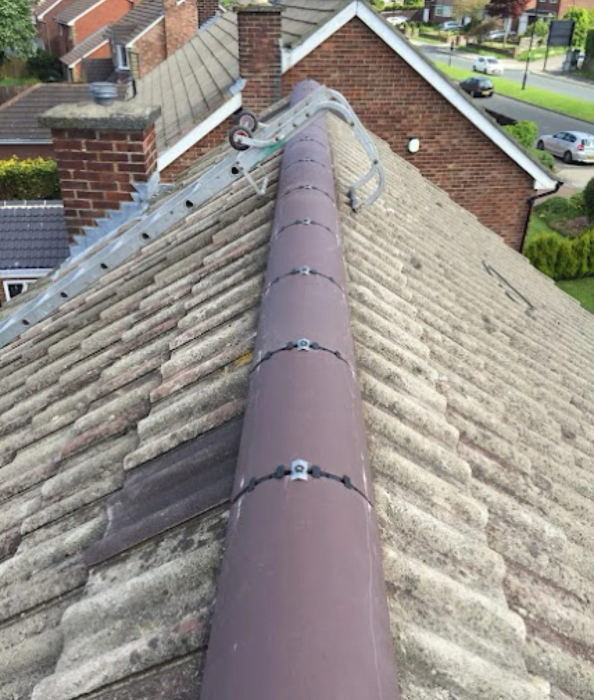 Half-round ridge tiles bedded along the apex of a tiled roof