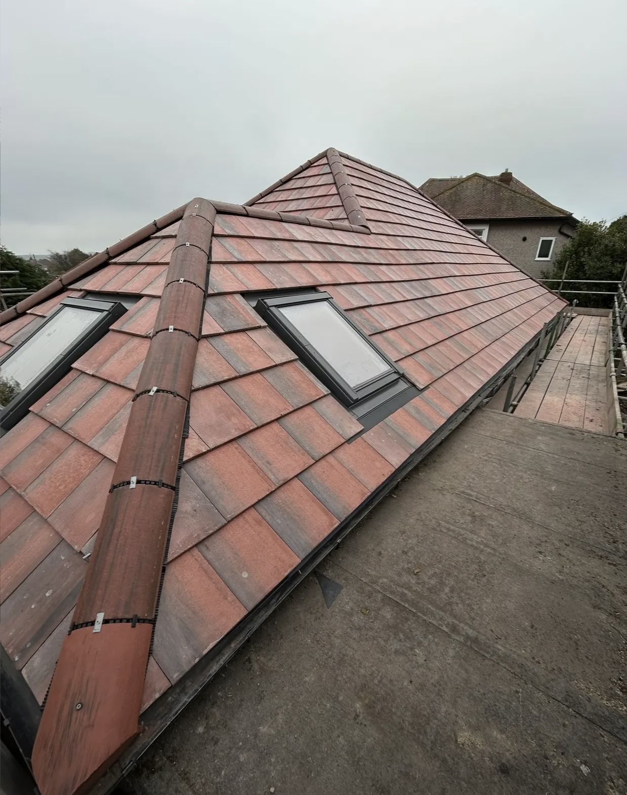 Red tiled roof with a rooflight, photographed from the scaffold at ridge height