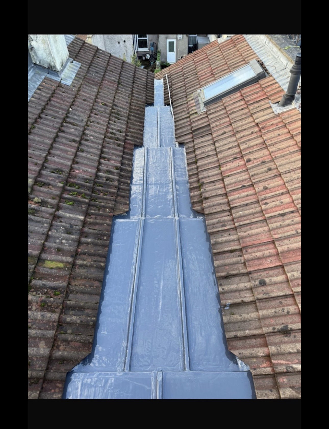 Lead valley running between two tiled roof slopes with skylights nearby