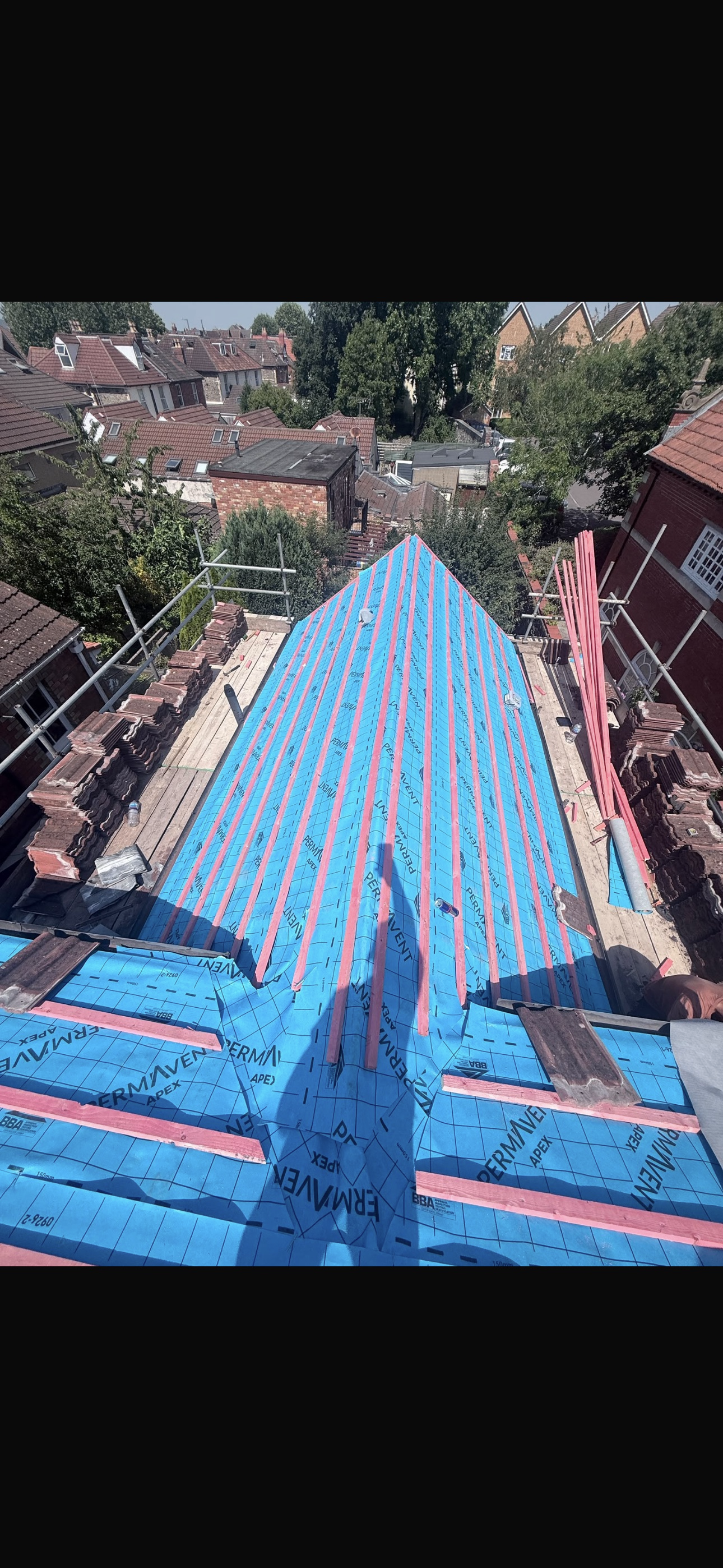 Roof valley prepared with blue underlay between rows of tiles