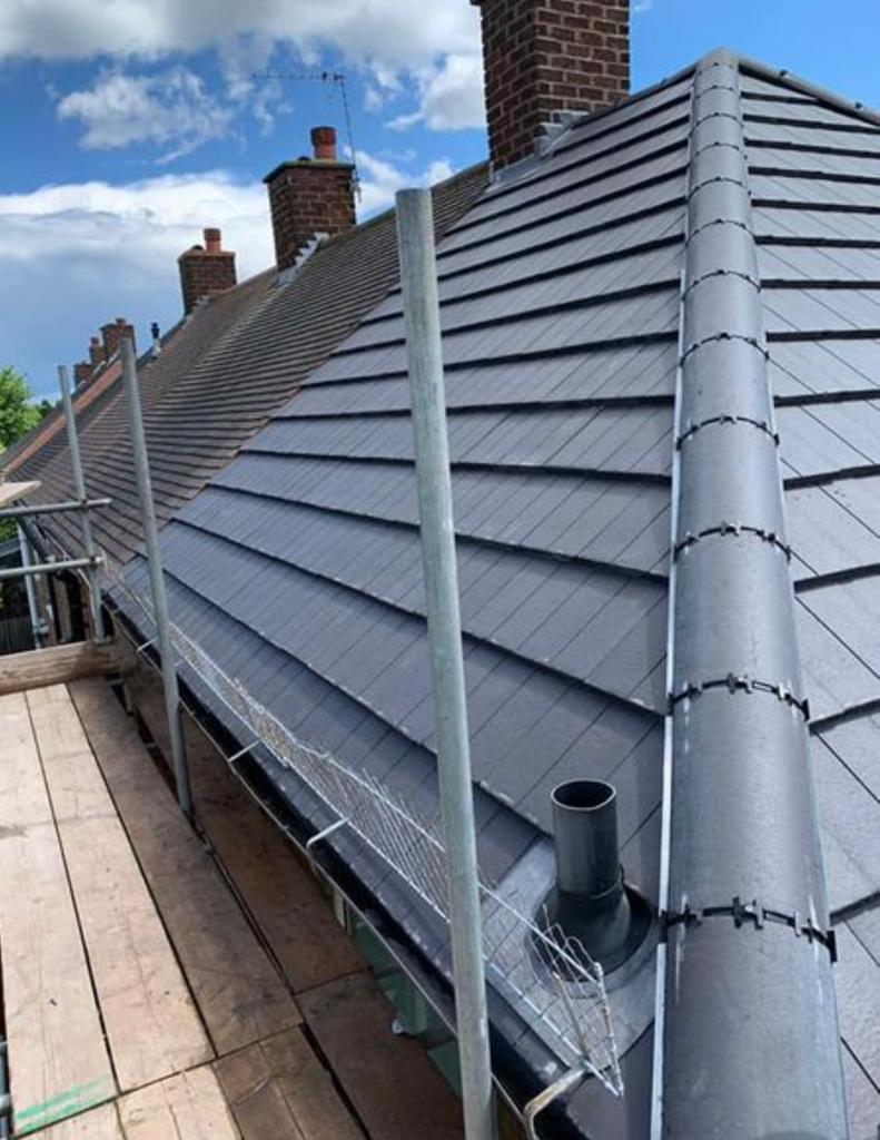 Grey tiled roof with ridge tiles and a flue