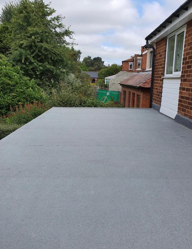 Large completed grey flat roof behind a house