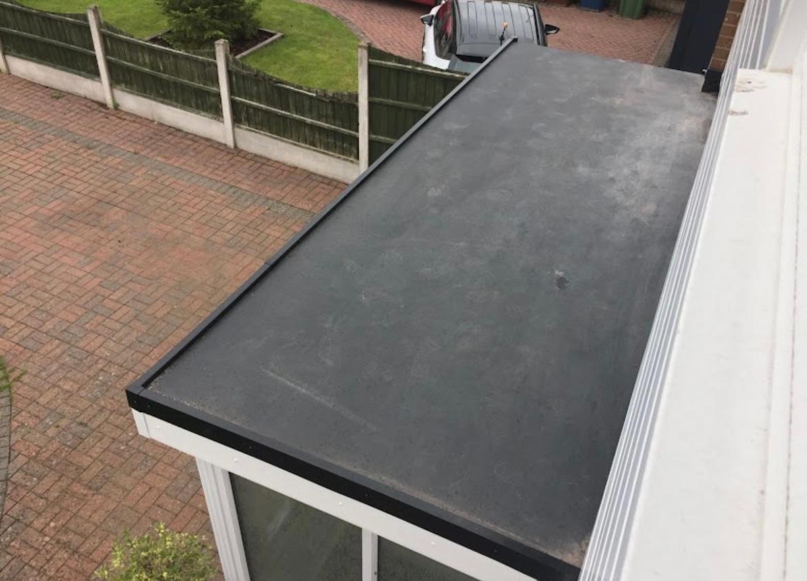 Completed dark flat roof over a ground-floor extension