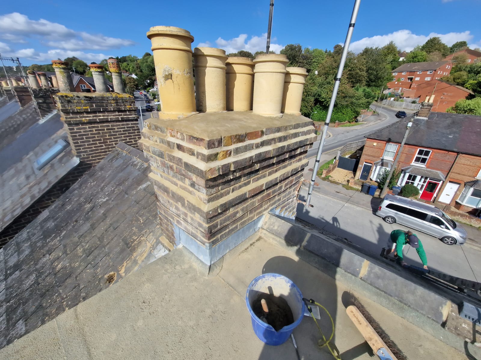 Brick chimney stack under repair from roof level