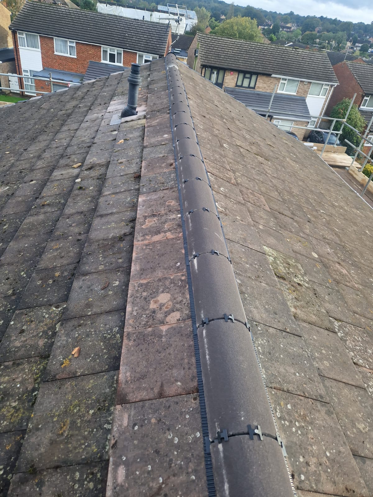 Ridge line prepared for repair on a weathered tiled roof
