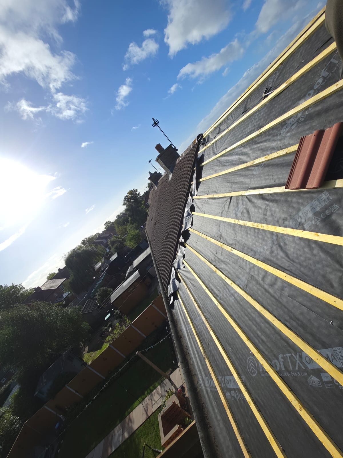 Close view of new battens and membrane on a roof slope against a bright sky