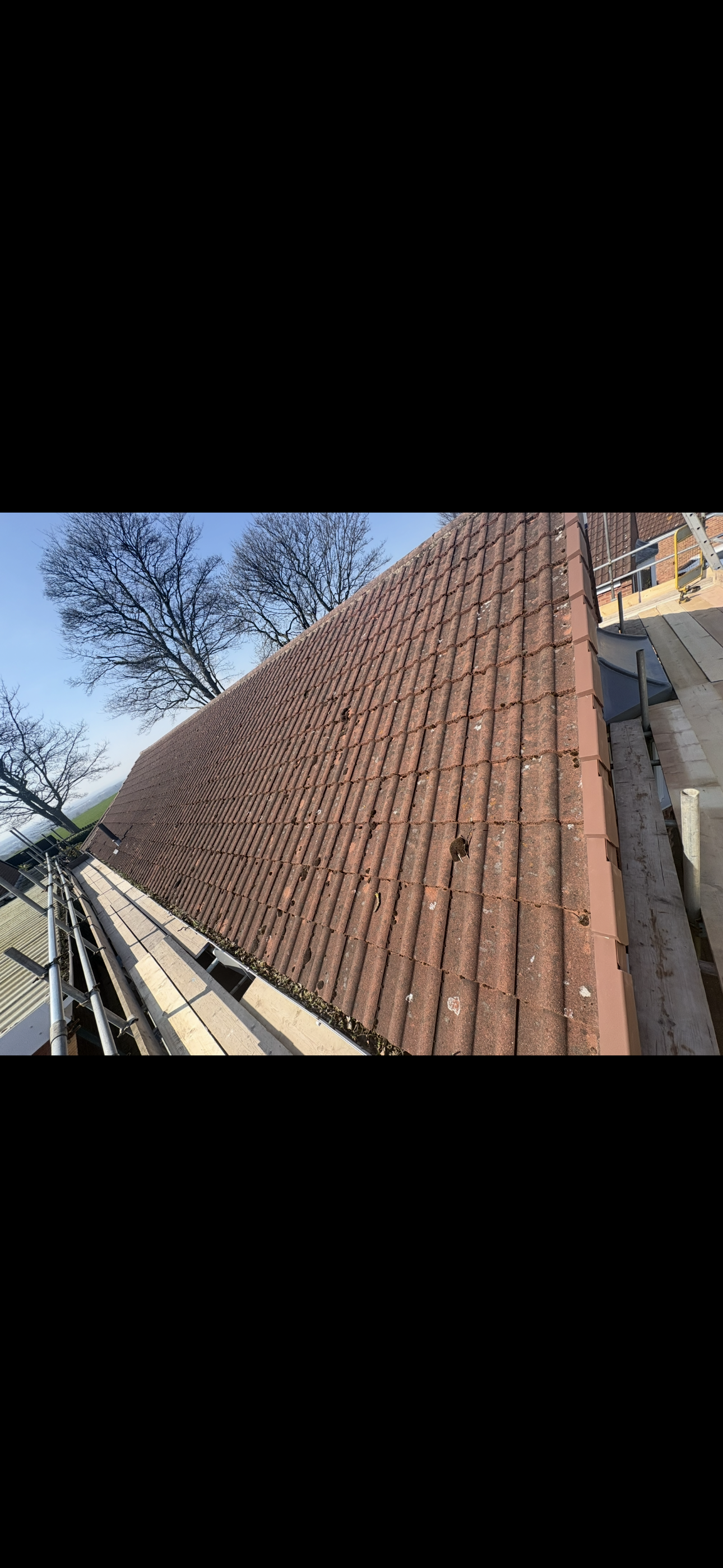 Section of roof with flashing dressed in against brickwork