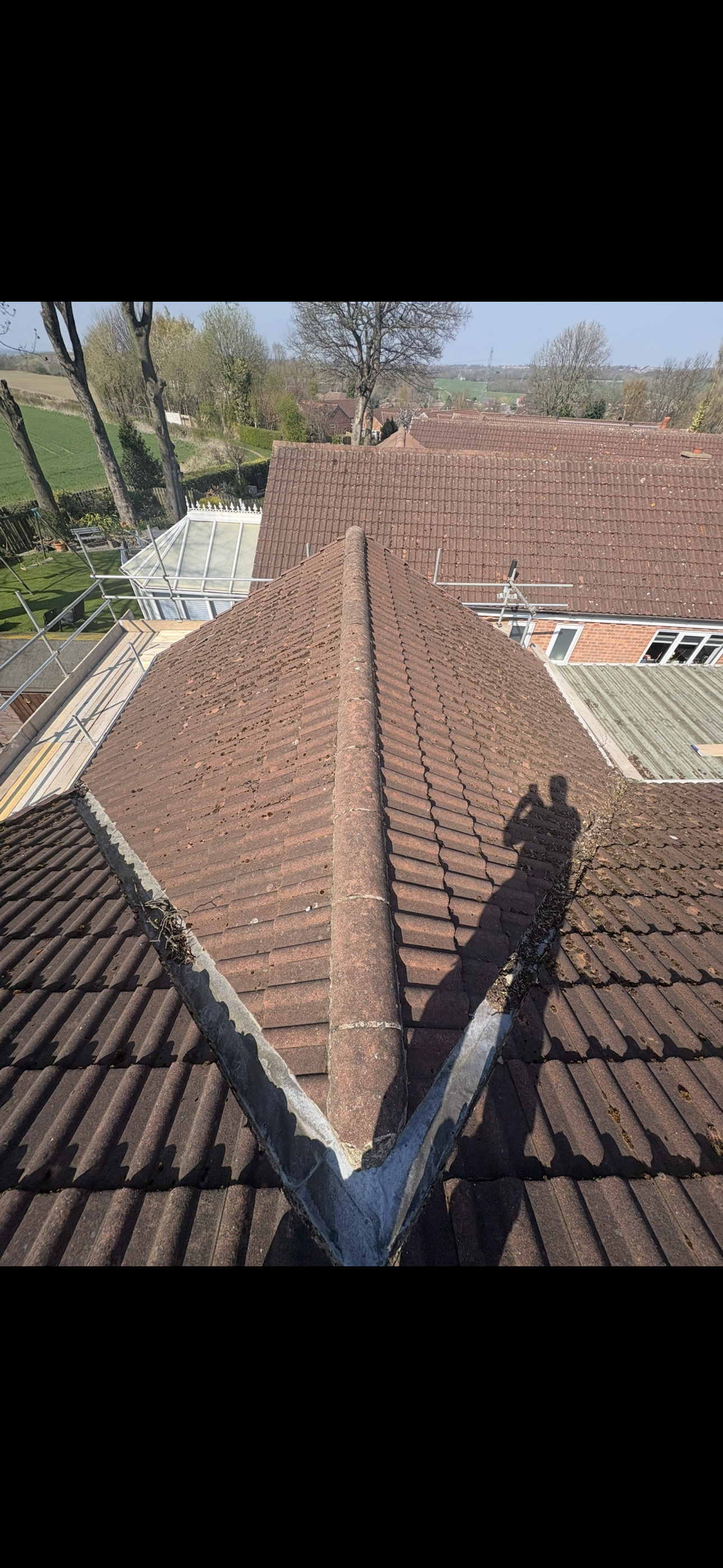 Tiled roof slope with scaffolding boards in the foreground