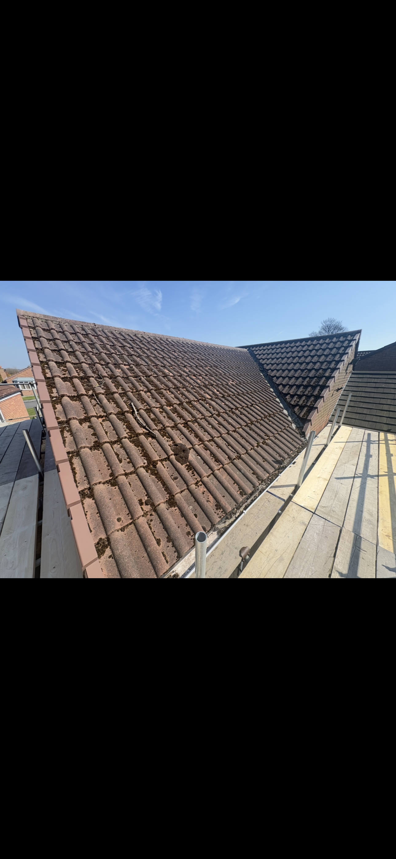 Ridge of a roof with tiles bedded and pointed along the apex