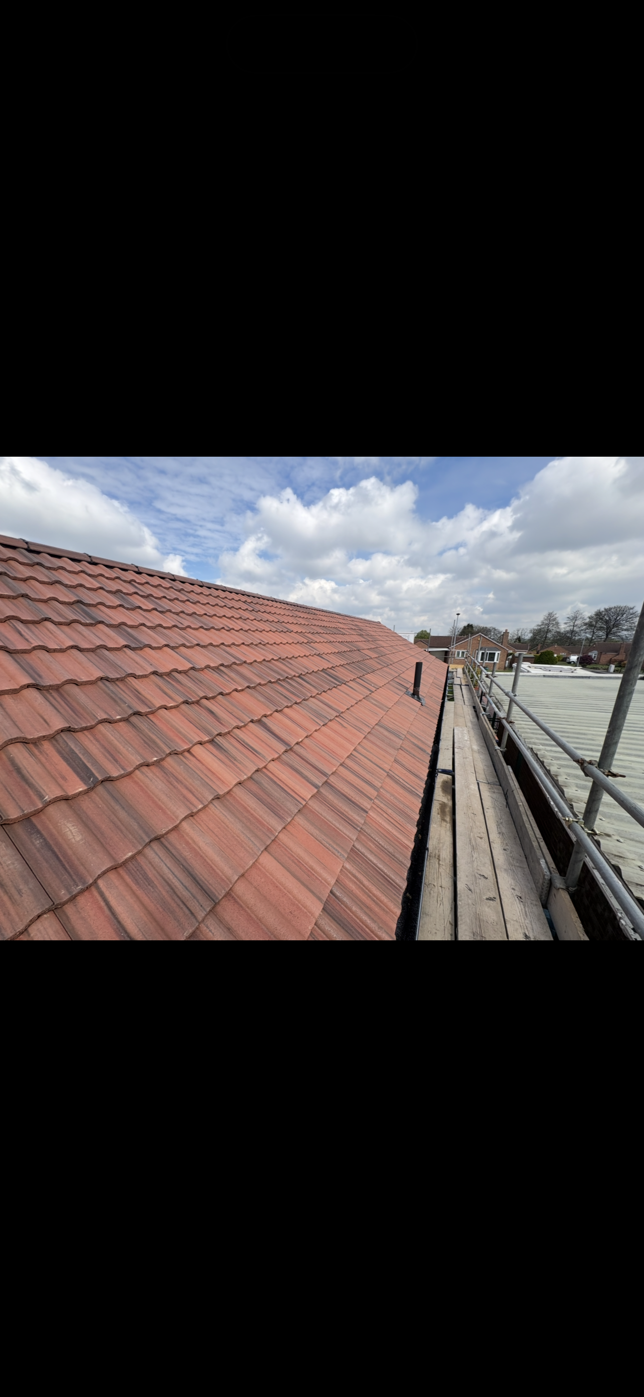 Long run of tiled roof with even courses across the whole slope